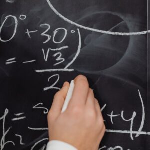 chalk board with person writing equations