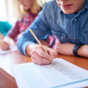 young adult writing with a pencil