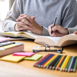 collection of stationery with person writing in a book